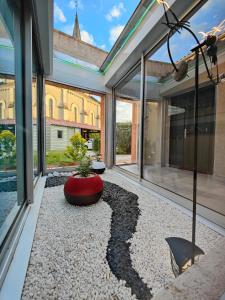 Cette chambre dispose de grandes fenêtres avec une plante en pot au milieu. dans l'établissement Gîte Le Petit Bambou, à Bressuire