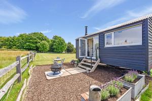 a blue tiny house in a yard with a fence at Crabden Shepherd Hut - Blendworth in Waterlooville