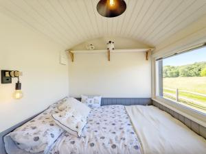 a bed in a room with a window at Crabden Shepherd Hut - Blendworth in Waterlooville