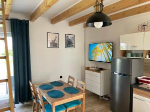 a kitchen and dining room with a table and a refrigerator at Domek nad Stawem in Kłodzko