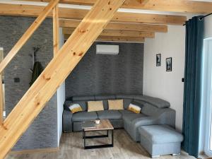 salon z kanapą i drewnianymi schodami w obiekcie Domek nad Stawem w Kłodzku