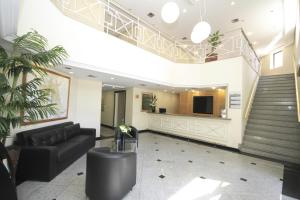 a lobby with a black couch and a staircase at Bienal Suítes in Sao Paulo