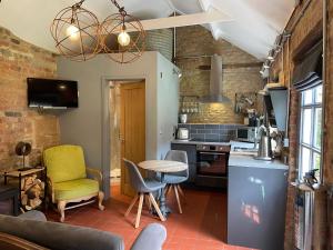 eine Küche mit einem Tisch und Stühlen im Zimmer in der Unterkunft Topiary Barn - Stylish Accommodation in Rutland in Uppingham