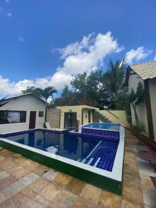 a swimming pool with blue tiles in front of a house at Pousada Cabana in Jericoacoara