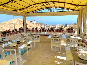 a restaurant with tables and chairs and a view of the ocean at Residenza il Barone in Tropea