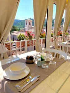 a table with plates and utensils on top of a balcony at Residenza il Barone in Tropea