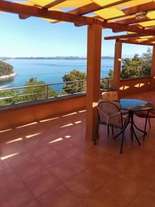 balcón con mesa y vistas al océano en Apartmani Frka, en Sali