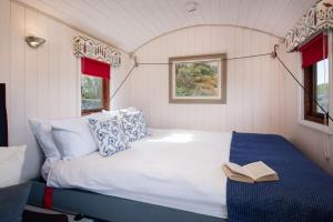 a bed in a small room with a book on it at Foxglove Shepherd's Hut in Berwick-Upon-Tweed