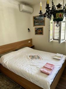- une chambre dotée d'un lit avec des draps blancs et un lustre dans l'établissement Apartment Dimeski, à Ohrid