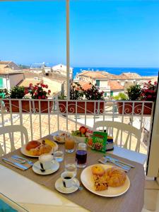 stół z talerzami jedzenia i widokiem na ocean w obiekcie Residenza il Barone w Tropei