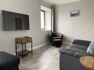 a living room with a couch and a table at Sea Breeze Apartment Wick in Wick
