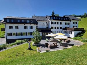 a view of a hotel with tables and umbrellas at Hotel Cristal Flumserberg in Flumserberg