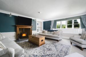 a living room with a couch and a fireplace at Summergreen Farmhouse in Bampton