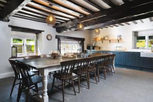 a kitchen with a large wooden table and chairs at Summergreen Farmhouse in Bampton