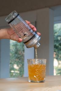 a person pouring a drink from a juicer into a glass at Amalthia in Skala Potamias