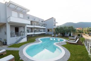 an apartment with a swimming pool in front of a building at Amalthia in Skala Potamias