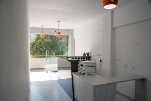 een keuken met witte muren en een groot raam bij Amalthia in Skala Potamias
