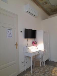 Pokój z białym biurkiem i telewizorem na ścianie w obiekcie B&B Villino Luschi Pisa Centro w Pizie +37 zdjęć