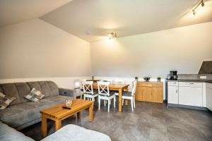 a living room with a couch and a table at Nordsee Ferienwohnung Möwe in Thunum
