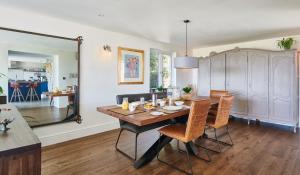 a dining room with a table and chairs and a mirror at Luxurious property set in the heart of Cornwall with breathtaking views -Rhubarb Cottage in Helston