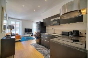 a kitchen with a counter top and a living room at Superbe 3 pieces Moderne et tres Central A2B233 in Cannes