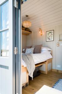 um quarto com uma cama num quarto em Boutique Cornish Shepherd's Hut with Hot Tub em Launceston