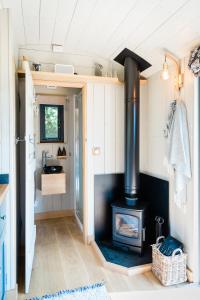 a kitchen with a stove in a tiny house at Boutique Cornish Shepherd's Hut with Hot Tub in Launceston