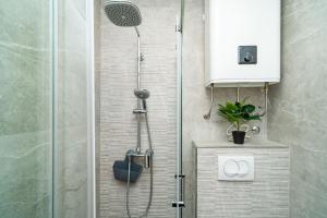 a shower with a glass door in a bathroom at Apartment & Rooms Papa in Mlini