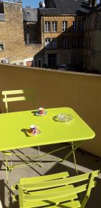 a green table and two chairs on a balcony at Appart plein centre, balcon, 4 personnes in Sedan