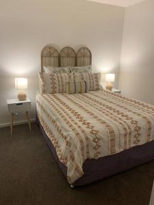 een slaapkamer met een groot bed met 2 lampen bij Plush at Dawn, Canberra city in Canberra