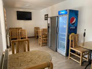 a room with a pepsi machine and tables and chairs at Oázis Panzió in Gyenesdiás