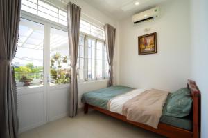 una camera con letto e finestra di Nhà đầy nắng homestay a Nha Trang