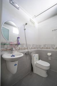 bagno con lavandino, servizi igienici e specchio di Nhà đầy nắng homestay a Nha Trang