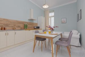 a kitchen with a table and chairs in a room at Apartments Aleje Jerozolimskie 85 by Renters in Warsaw