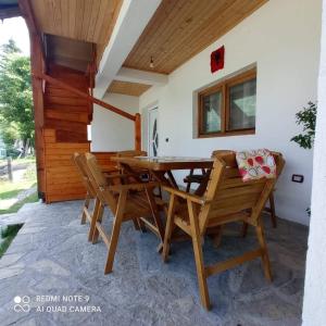 comedor con mesa de madera y sillas en Bujtina Albjoni en Valbonë