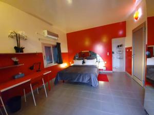 una camera con letto e parete rossa di TérangaLux Villa A Vue Mer avec Piscine Saint Louis Sénégal a Guet Dar