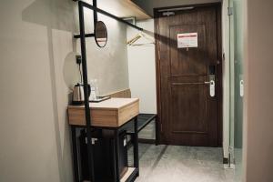 a bathroom with a sink and a wooden door at Amigo Hotel in Miri