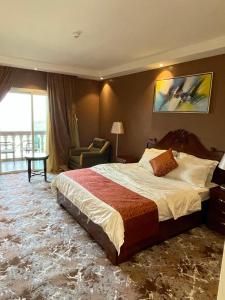 a hotel room with a large bed and a chair at Green View Hotel in Abha