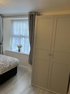 a bedroom with a large closet and a window at Ground Floor 1 Bedroom Apt With Parking, Edge of Glastonbury and Street in Street