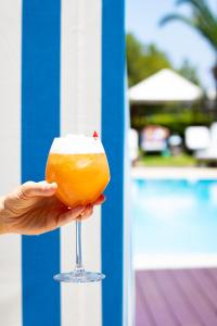 a person holding a drink in a wine glass at Grande Albergo Delle Rose in Rhodes Town