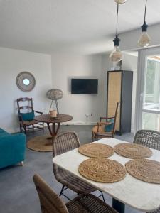 a living room with tables and chairs and a tv at "Lou Mes" Les baux Balcon in Les Baux-de-Provence