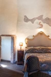 a bedroom with a bed and a table and a lamp at Hotel Della Fortezza in Sorano