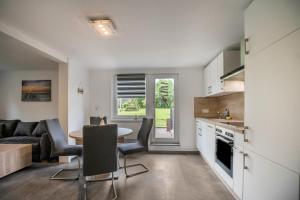 eine Küche und ein Wohnzimmer mit Tisch und Stühlen in der Unterkunft Ferienwohnung 9 und 40 in Thunum