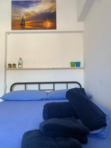 Una cama con almohadas azules encima. en Favignana: La porta sul mare en Favignana