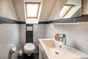 a small bathroom with a sink and a toilet at Nordsee Ferienwohnung Möwe in Thunum