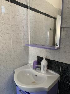a white sink in a bathroom with a mirror at Favignana: La porta sul mare in Favignana