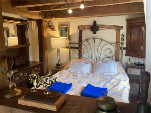 a bedroom with a bed with blue pillows and a table at Little Pentre Barn with cozy logburner in Wrexham +102 photos