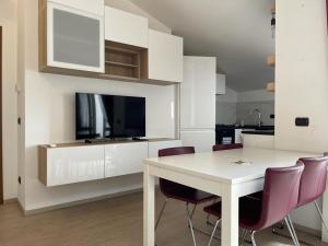 uma cozinha e sala de jantar com uma mesa branca e cadeiras em Kibilù - Brebbia Bilocale con Piscina Parcheggio vicinanze Lago Maggiore em Brebbia