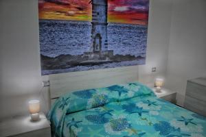 a bedroom with a bed with a painting on the wall at tommy house in Calasetta