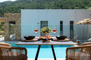 a table with two glasses of wine on a patio at Soho Exclusive Suites in Skala Potamias